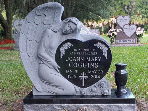 Close view of a carved angel resting on a black granite heart